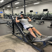 Man using a leg press machine in a gym setting
