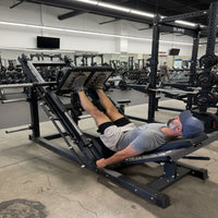 Person using a leg press machine in a gym setting