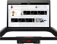 Peloton treadmill with screen displaying workout classes on a white background