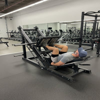 Person using a leg press machine in a gym setting