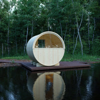 Wooden barrel-shaped structure on a platform over water with trees in the background