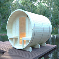 Wooden barrel-shaped sauna on a wooden platform by a body of water with trees in the background.