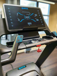 Close-up of a treadmill control panel with digital display and buttons.