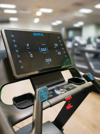 Close-up of a treadmill control panel with digital display in a gym setting