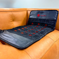 Massage mat with red nodes on a brown leather couch