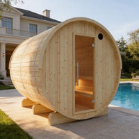 Wooden barrel-shaped sauna outdoors near a pool and house