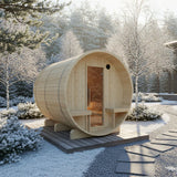 Wooden barrel-shaped sauna in a snowy outdoor setting with trees and pathways.