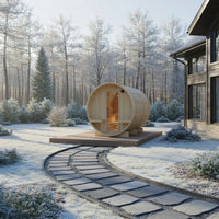 Wooden barrel-shaped structure in a snowy landscape with a house in the background