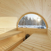 Wooden sauna interior with a large window showing a snowy landscape outside.