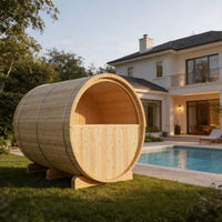 Wooden barrel-shaped outdoor sauna in a backyard with a pool and house in the background.