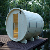 Wooden barrel-shaped sauna on a platform by a body of water with trees in the background