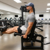 Man exercising on a leg press machine in a gym.