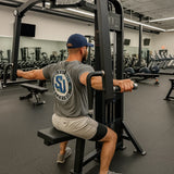 Man exercising on a cable machine in a gym setting