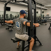 Man exercising on a cable machine in a gym setting
