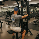 Man exercising on a gym machine in a well-equipped gym.