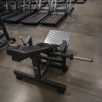 Black weight bench with weight plates on a concrete floor in a gym setting